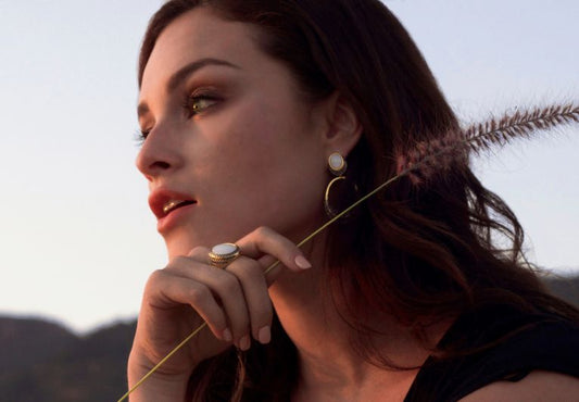 mujer con rama de planta y joyas